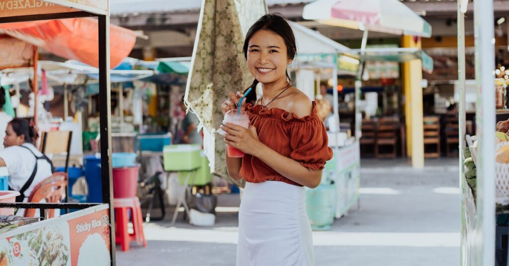 Cheerful woman holding a drink, enjoying her time at a vibrant Thai street market.